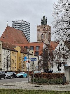 Street view with Marienkirche church tower, Oderturm high-rise, parked cars, and houses
