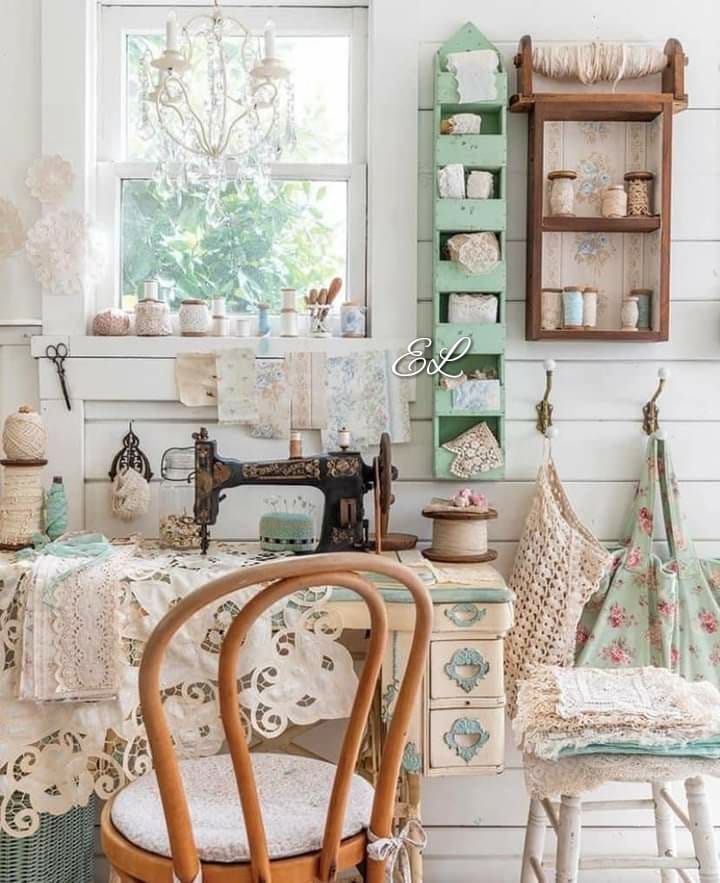 Vintage sewing room with antique machine, wooden chair, green shelves, lace curtains and rustic cottage decor