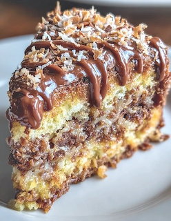 Slice of layered German chocolate cake with coconut pecan filling and chocolate drizzle on a white plate