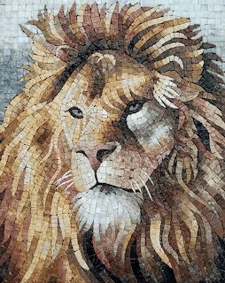 Mosaic artwork of a lion's head and mane made from small stone tiles in brown and gold tones