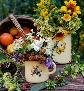 Autumn floral arrangement with sunflowers and pumpkins in rustic vases on wooden table