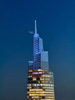 Illuminated modern skyscraper against a deep blue evening sky