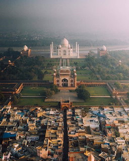 Aerial photograph of Taj Mahal complex with surrounding gardens and town buildings in foreground