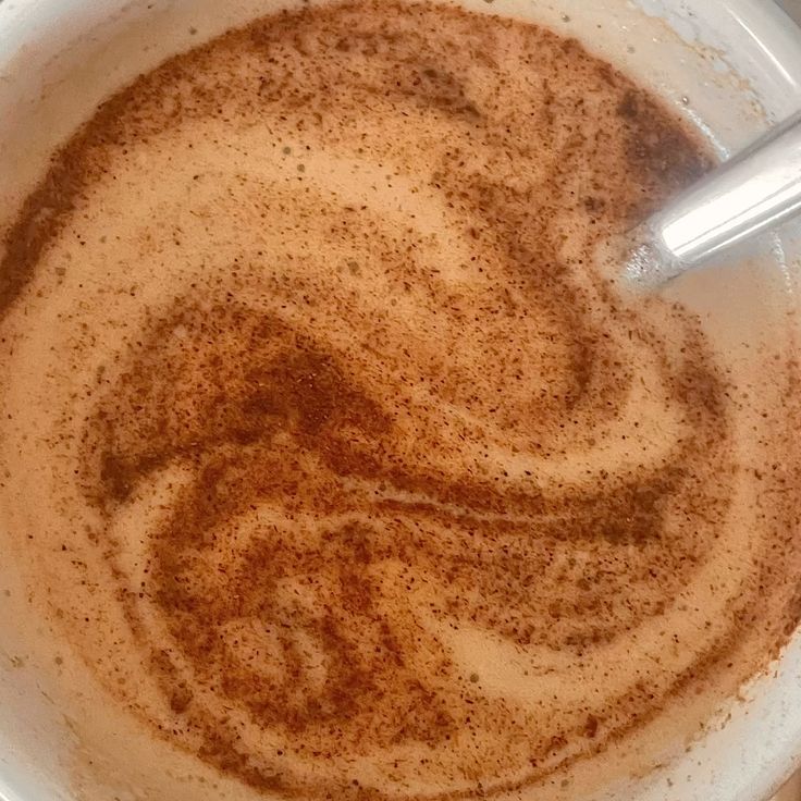 Overhead view of chai latte with cinnamon swirl pattern in white cup
