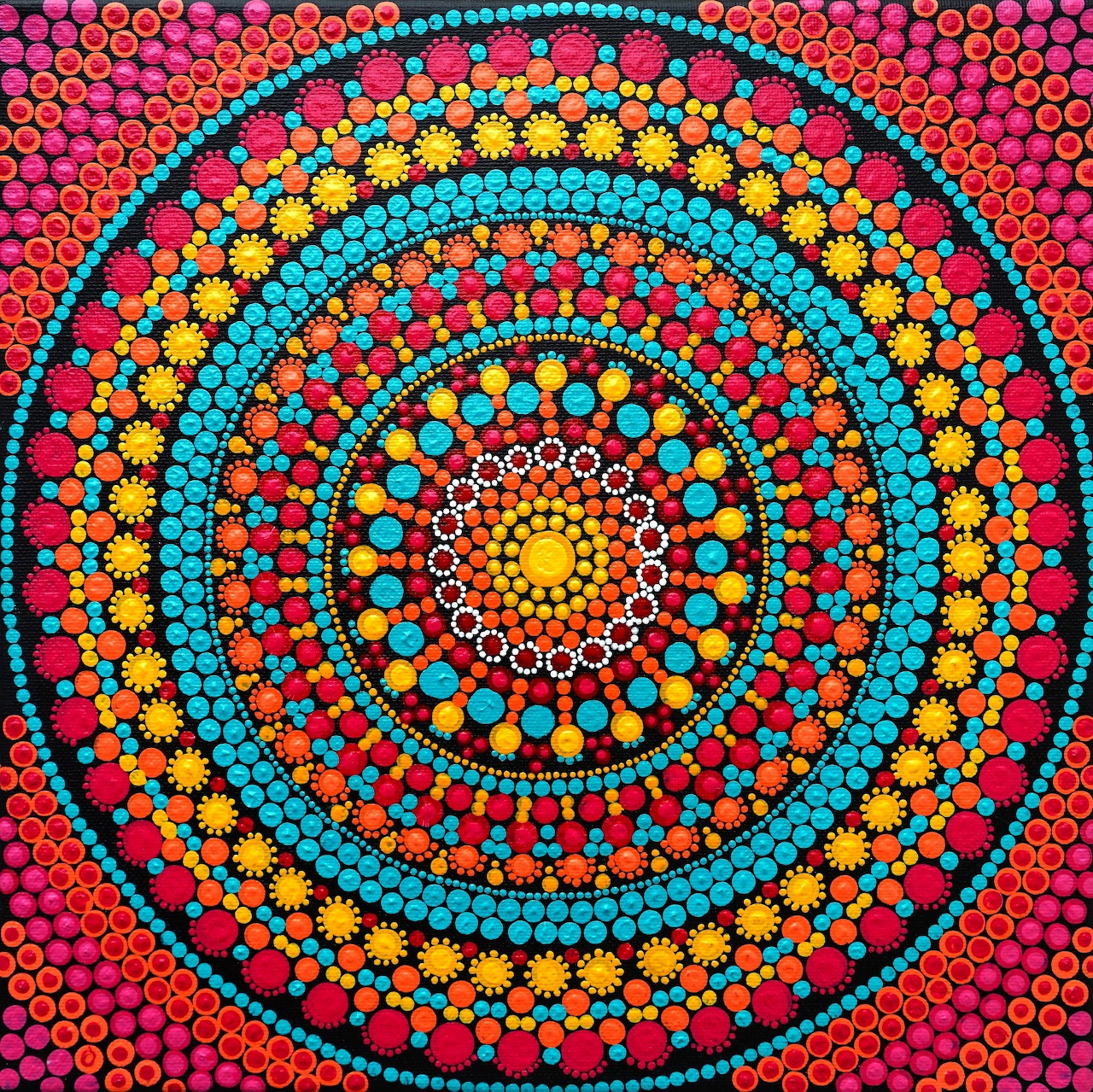 Vibrant dot mandala with concentric circles of red, turquoise, yellow and orange dots on dark background