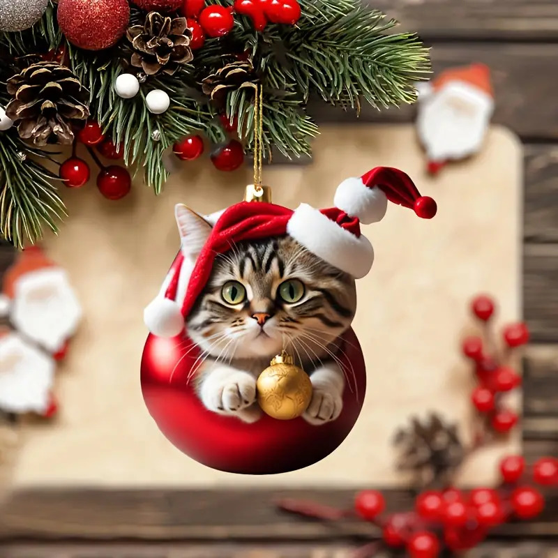 Tabby cat inside a red Christmas ornament with pine branches, pinecones, and red berries