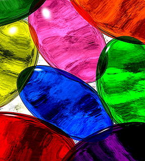 Overlapping translucent glass bowls in rainbow colors with light shining through creating vibrant reflections