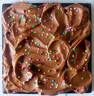 Top view of a chocolate frosted cake with colorful sprinkles