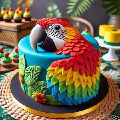 Colorful parrot-shaped cake with rainbow feathers and tropical leaf decorations on a blue fondant base