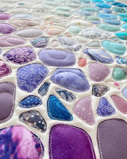 Handmade quilt with colorful sea glass shaped fabric patches stitched together