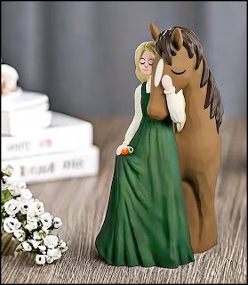 Figurine of girl in green dress with brown horse on wooden table