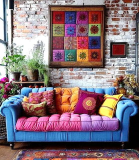 Bright blue sofa with colorful pillows against exposed brick wall with vibrant artwork and plants