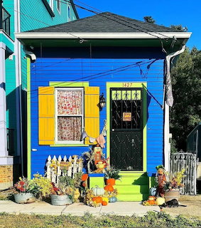 Blue house with yellow trim decorated with pumpkins and fall decorations for Thanksgiving
