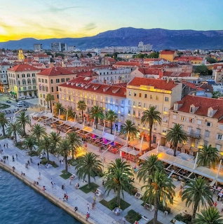 Aerial sunset view of Split Croatia waterfront with palm-lined promenade and historic buildings