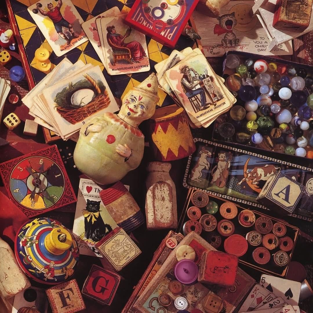 Flat lay of vintage toys, games, wooden blocks, marbles, and colorful trinkets scattered together