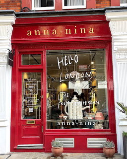 Red painted storefront of Anna Nina shop with large display window and entrance door in Amsterdam