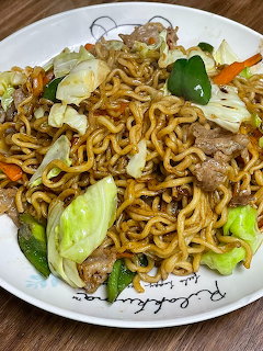 Plate of yakisoba stir-fried noodles with vegetables and meat on a white plate