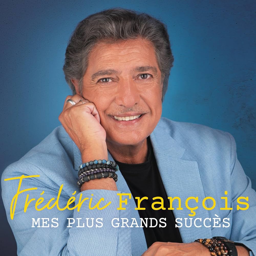 Portrait of Frédéric François smiling in a light blue blazer against a blue background
