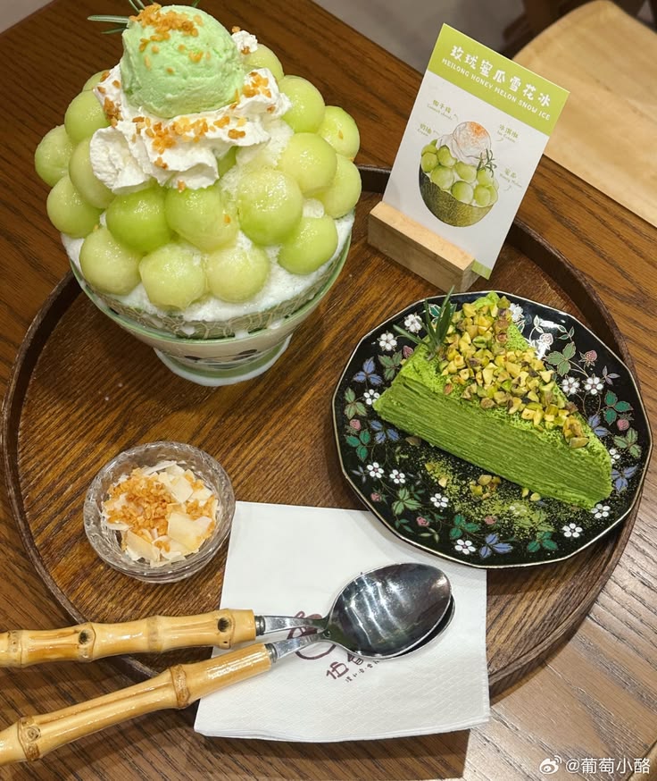 Melon shaved ice dessert with a green cake slice and small pudding on a wooden tray