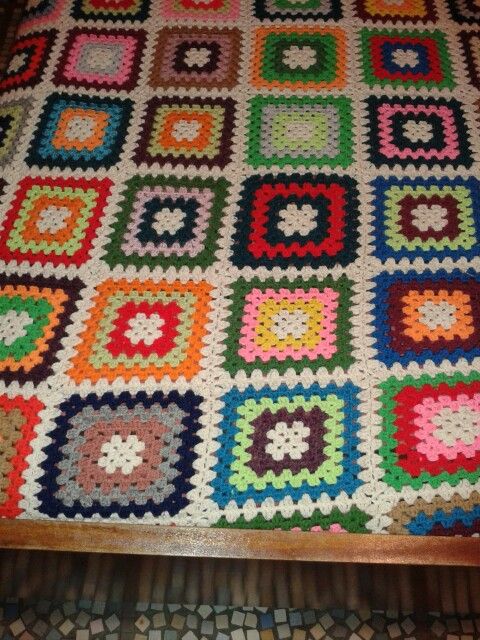 Colorful crocheted granny square blanket with repeating multicolor patchwork pattern