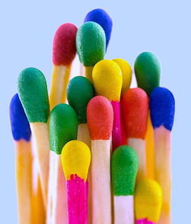Close-up of colorful matchsticks with red, blue, green, yellow, pink, and orange heads arranged vertically