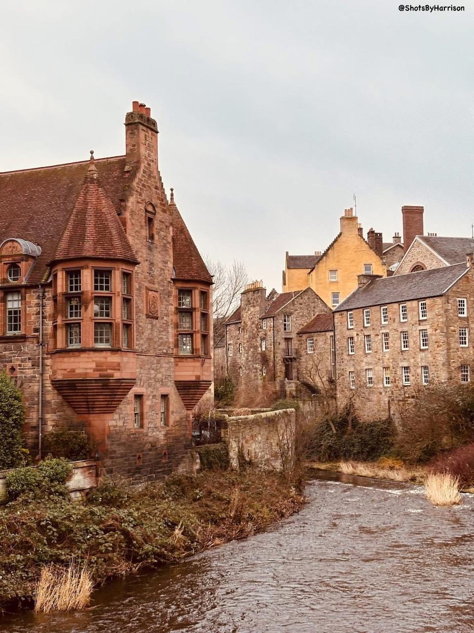 Stone buildings and a river in Dean Village, Edinburgh, Scotland on an overcast day