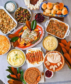 Overhead view of Mediterranean holiday meal with casseroles, vegetables, pies, and side dishes