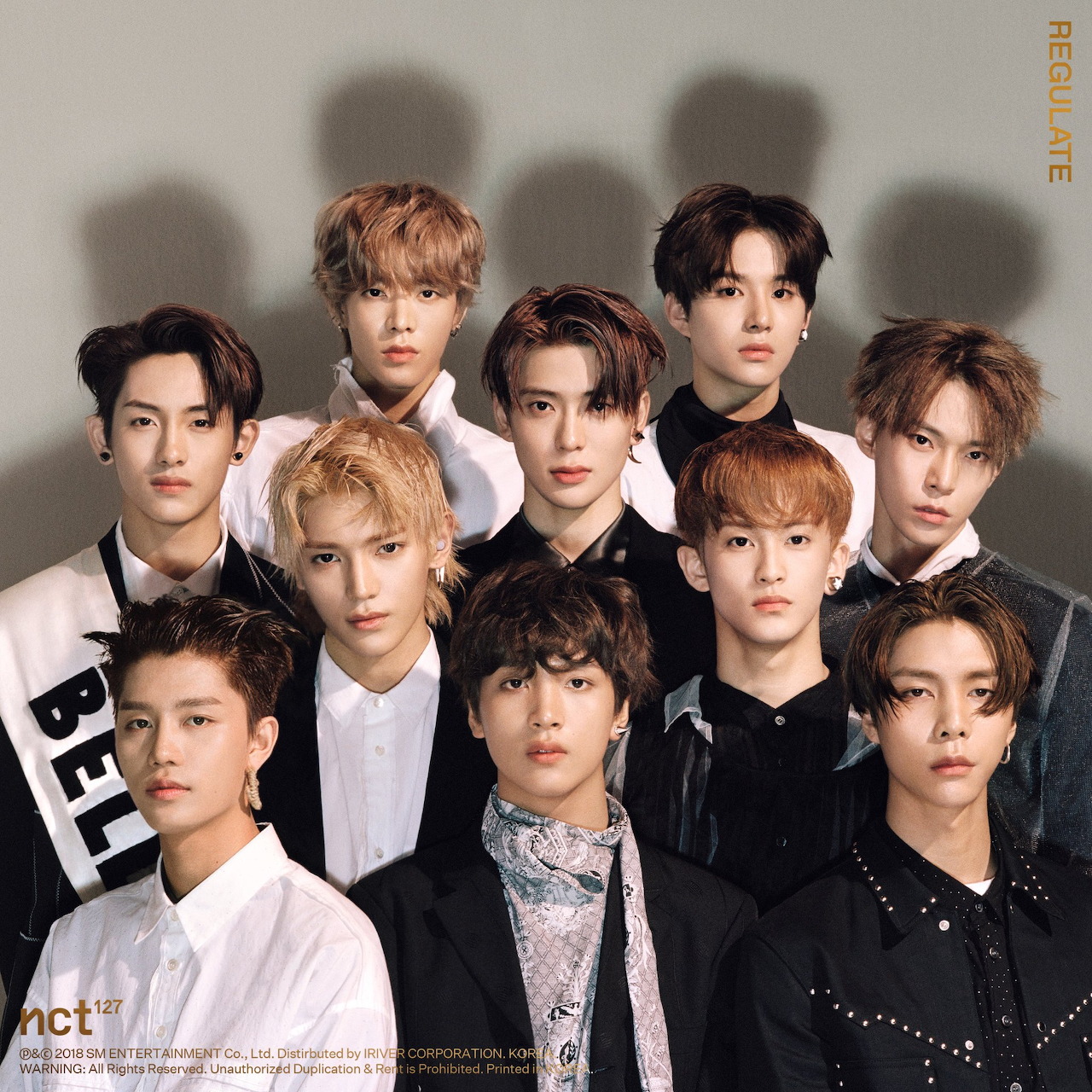 NCT127 K-pop group portrait with ten members in black and white formal wear
