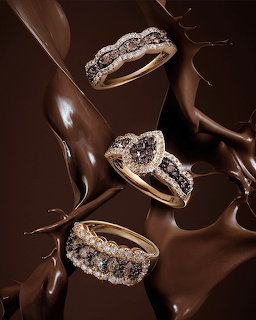 Three diamond gold rings on a glossy brown splash background