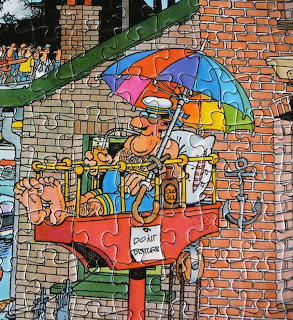 Cartoon man lounging on a red balcony with a colorful umbrella and do not disturb sign on a brick building
