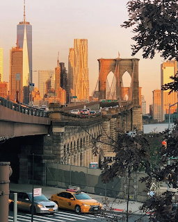 Brooklyn Bridge and Lower Manhattan skyline at sunset with One World Trade Center