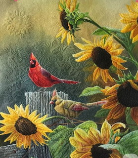 Painting of a red cardinal and finches among yellow sunflowers