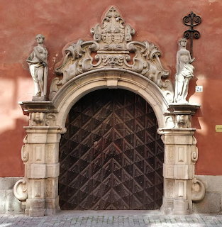 Baroque stone doorway with sculptural details and dark wooden door in Stockholm, Sweden