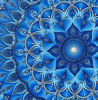 Intricate blue mandala with floral petals, dotted patterns, and a glowing center