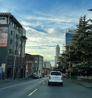 Seattle street scene with Smith Tower visible in distance under sunset sky