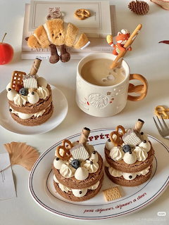 Overhead flat lay of chocolate layered cakes, croissants, coffee mug, and pastries on white table