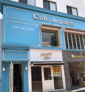 Blue Cafe de Paris storefront with ornate signage and decorative architectural details
