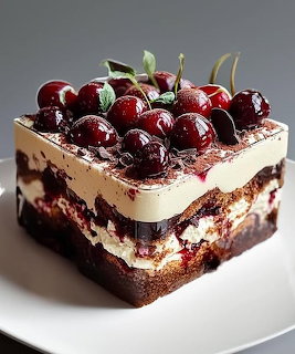 Slice of layered tiramisu cake with chocolate, cream, and fresh cherries on top