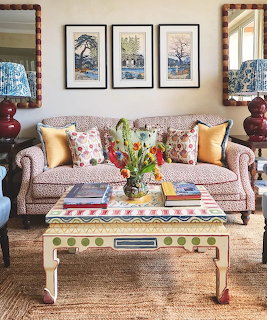 Living room with leopard print sofa, yellow pillows, tulip bouquet on coffee table, and wall art