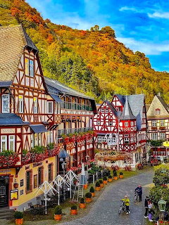 Colorful half-timbered buildings in Bacharach, Germany with autumn vineyard hillside