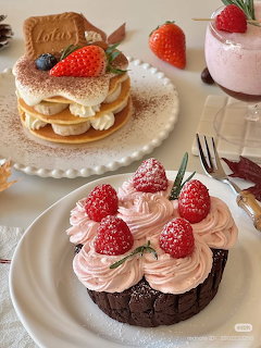 Strawberry desserts on white plates including chocolate cake with pink frosting and layered cookie sandwich