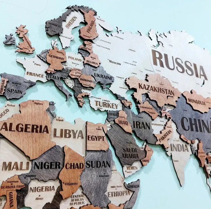Close-up of a wooden world map with labeled countries in Europe, Asia, and Africa