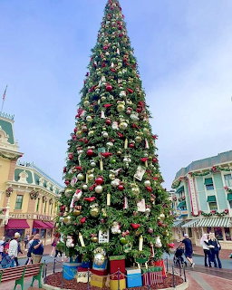 Tall Christmas tree decorated with ornaments and lights at Magic Kingdom Main Street USA