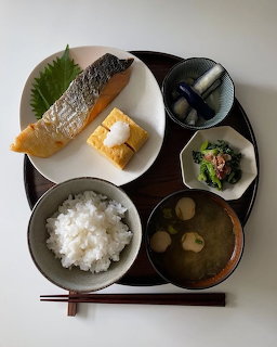 Japanese meal tray with grilled fish, tamagoyaki, steamed rice, miso soup, and vegetable side dishes