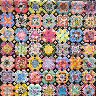 Colorful patchwork quilt with hexagonal granny square motifs in various floral and geometric patterns