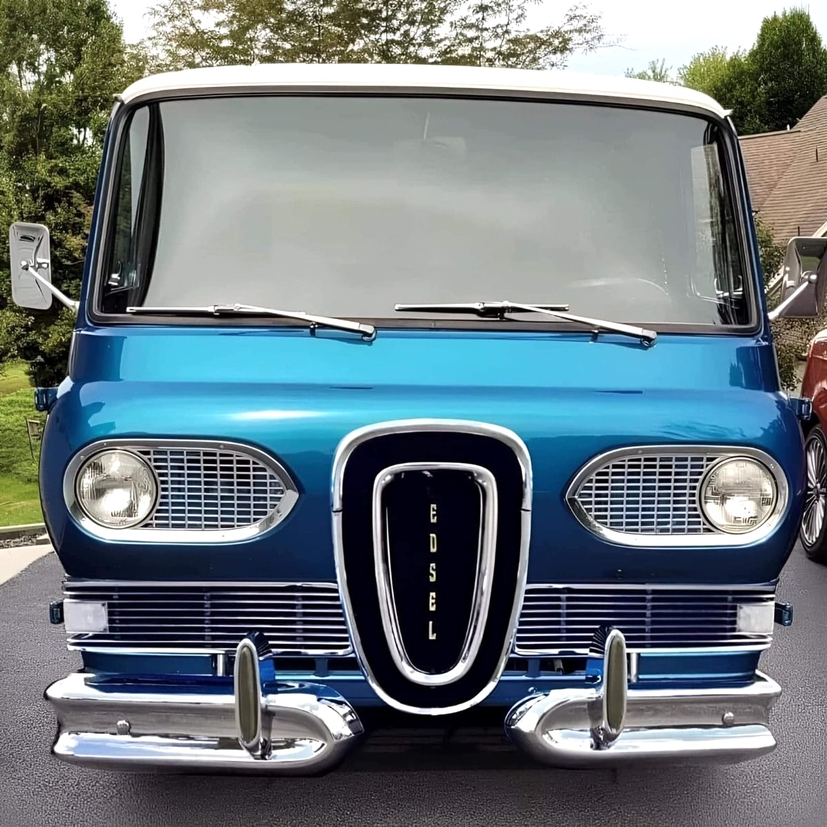 Front view of a classic blue and white Edsel car with chrome grille and bumper