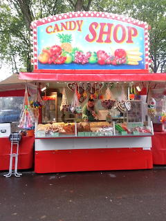 Colorful outdoor candy shop stall with sweets, lollipops, and candy displayed under a large sign