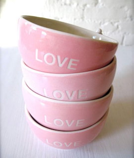 Four stacked pink ceramic bowls with LOVE text on white background