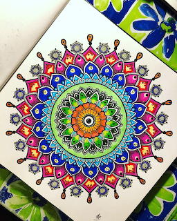 Colorful mandala with rainbow petals and geometric patterns radiating from yellow center