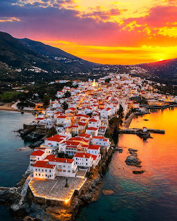 Aerial view of Andros Island Greece coastal town with white buildings at sunset